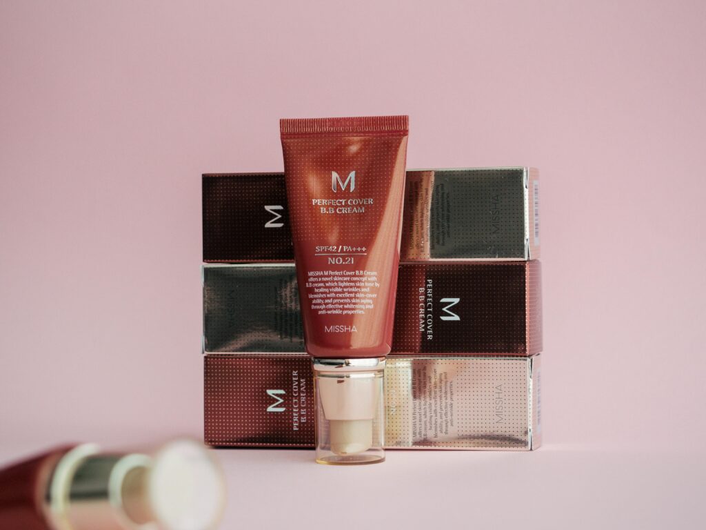 Manager produktu – kosmetyk prezentowany na tle opakowań symbolizujący zarządzanie produktem, jego rozwój i wprowadzanie na rynek.